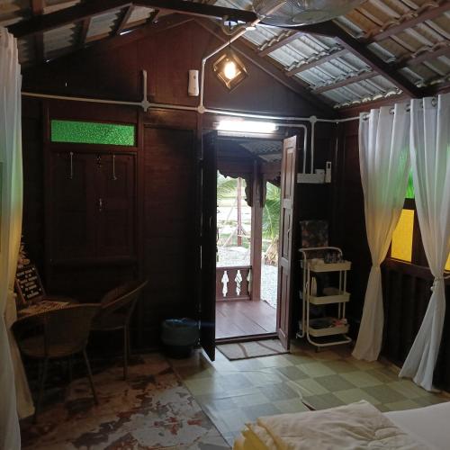 a room with a bed and a room with a door at Chinta Chinta Cottage Chalet Kayu in Arau