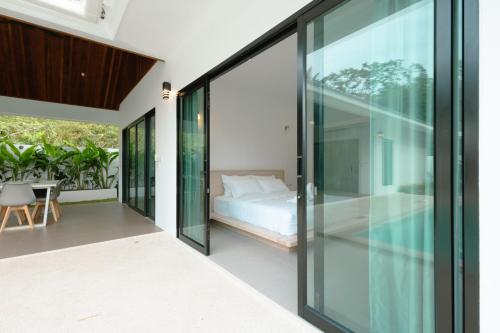 a bedroom with sliding glass doors leading to a bed at Samui Paradise Poolside Villa in Nathon Bay
