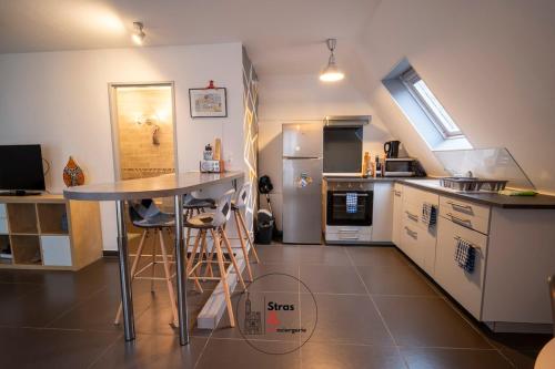 a kitchen with a counter and a table in it at Calme et Confort au Stockfeld in Strasbourg