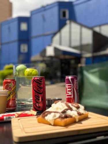 une table avec un sandwich et deux canettes de soda dans l'établissement ibis budget Belfort Centre, à Belfort