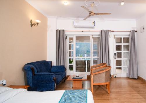 a bedroom with a blue chair and a blue couch at Neelesh Inn- A Luxury Lake View Hotel- 20 kms from Nainital in Bhīm Tāl