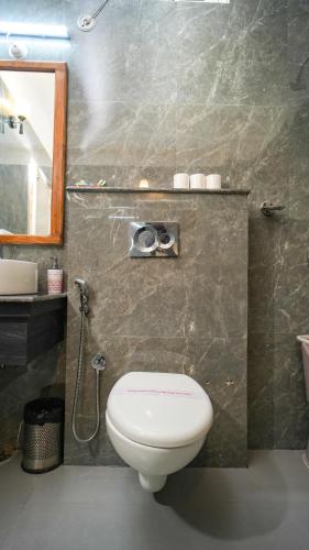 a bathroom with a toilet and a sink and a mirror at Neelesh Inn- A Luxury Lake View Hotel- 20 kms from Nainital in Bhīm Tāl