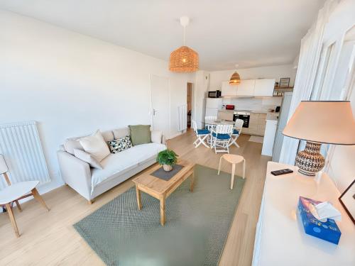 un salon avec un canapé et une table dans l'établissement Blonville sur Mer, 2 minute walk to beach, 2 parking spaces and balcony, à Blonville-sur-Mer