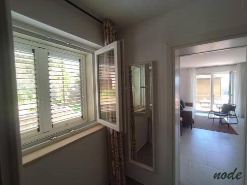 a room with two windows and a hallway with a chair at ELEVEN in Šibenik