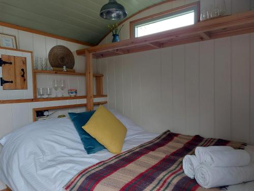 a bedroom with a bed with a yellow and blue pillow at Steam and Stars Luxury Glamping in Williton