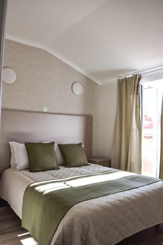 a bedroom with a large bed and a window at Residência Maciel in Peniche