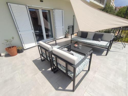a patio with chairs and a table and a couch at ELEVEN in Šibenik