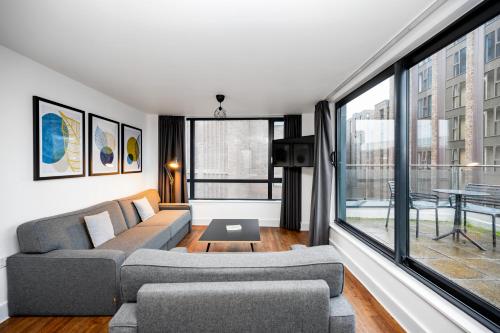 a living room with a couch and a large window at Staycity Aparthotels Liverpool City Centre in Liverpool