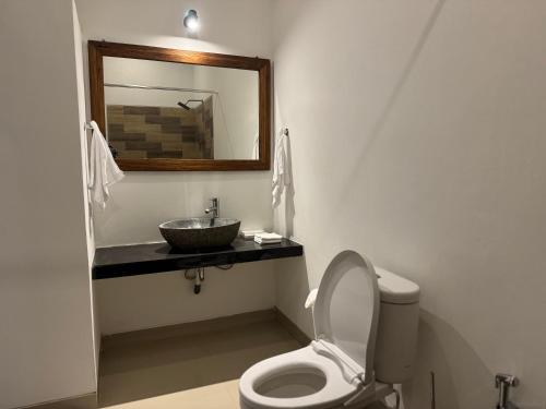 a bathroom with a sink and a toilet and a mirror at Gayatri in Ubud
