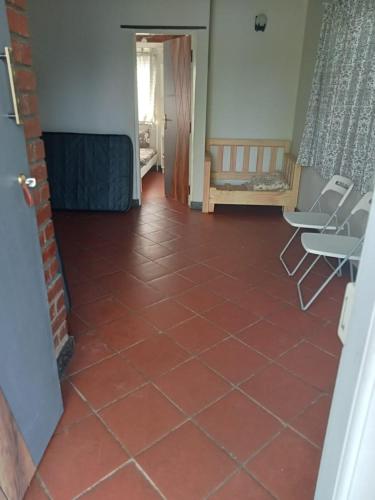 a room with a red tile floor and chairs at Medini Ecostay - Your Private Paradise in Kollegālam