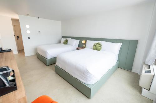 a bedroom with two beds with white sheets at Dayton Vitality Hotel - Downtown in Dayton