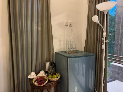 a blue cabinet with a lamp and a basket of fruit at Gayatri in Ubud