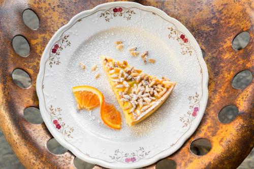 Un trozo de pizza en un plato con una rodaja de naranja en Villa Sestilia Guest House, en Montaione