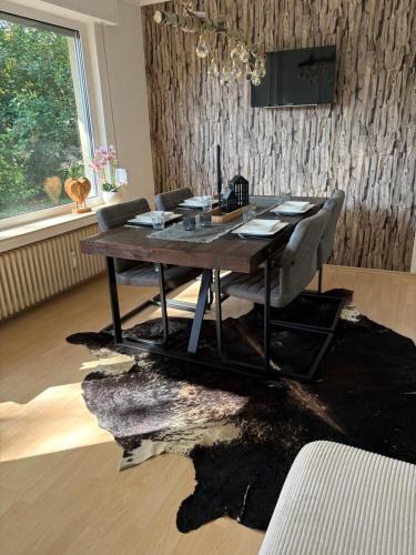a dining room with a wooden table and a black rug at Ferienwohnung Hennes in Remagen