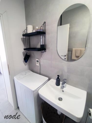 a white bathroom with a sink and a mirror at ELEVEN in Šibenik