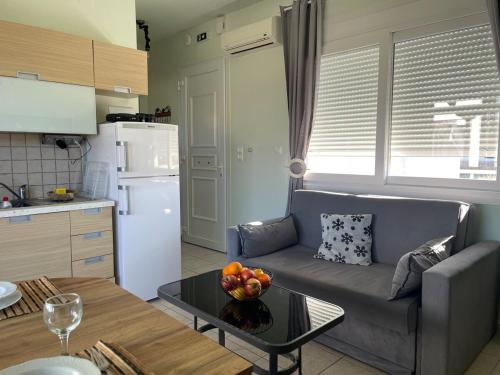 un salon avec un canapé et une table avec un bol de fruits dans l'établissement Lilikas Sea Front Apartments 4, à Lilikás