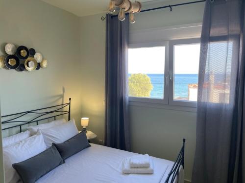 une chambre avec un lit et une fenêtre avec l'océan dans l'établissement Lilikas Sea Front Apartments 4, à Lilikás