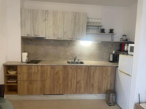 a kitchen with wooden cabinets and a sink at Villa Antorini in Sveti Vlas