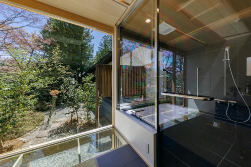 a glass bathroom with a view of the yard at Koyasan Sanadabo Rengejoin in Koyasan
