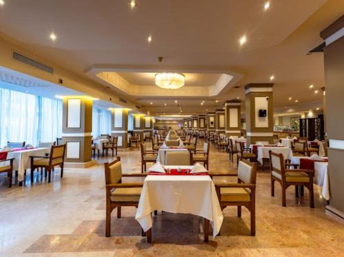 a dining room with tables and chairs in a restaurant at Regina Resort and Aqua Park Hurghada in Hurghada