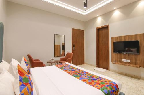 a hotel room with a bed and a flat screen tv at The Royal Court in Ludhiana