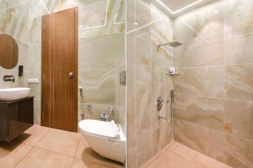 a bathroom with a shower with a toilet and a sink at The Royal Court in Ludhiana