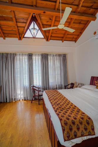a bedroom with a bed and a ceiling fan at Neelesh Inn- A Luxury Lake View Hotel- 20 kms from Nainital in Bhīm Tāl