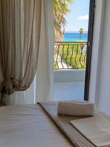 a bedroom with a bed and a view of the ocean at Villa Christina Sea Side A in Hanioti