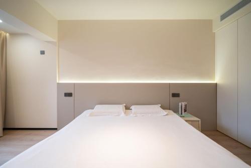 a bedroom with a large white bed with two pillows at Tonight Homestay West Nanjing Road Branch Shanghai in Shanghai
