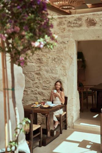 a woman sitting at a table in a building at Manili Boutique Suites & Villas in Archanes