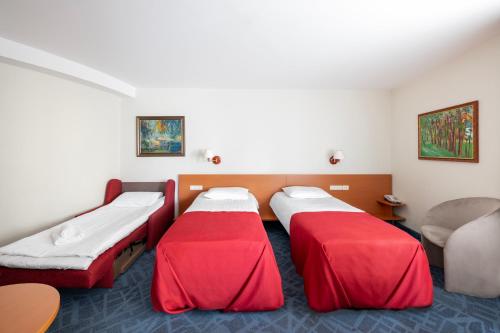 a hospital room with two beds and a chair at Art City Inn in Vilnius