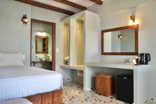 a bedroom with a bed and a sink and a mirror at Apágkio Filoxenia in Archangelos