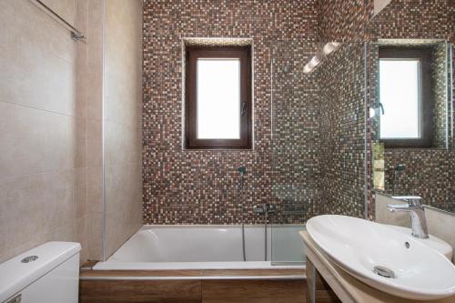 une salle de bain avec une baignoire et un lavabo dans l'établissement Roupes Villa II, Family villa, Fantastic views, Private pool, à Roúpai