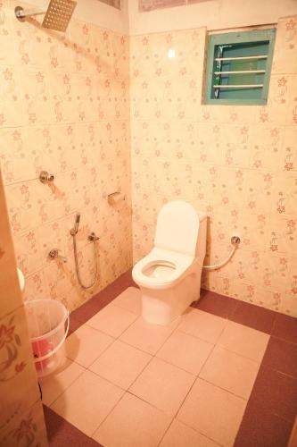 a bathroom with a toilet and a shower in it at TempleTree Inn in Varkala