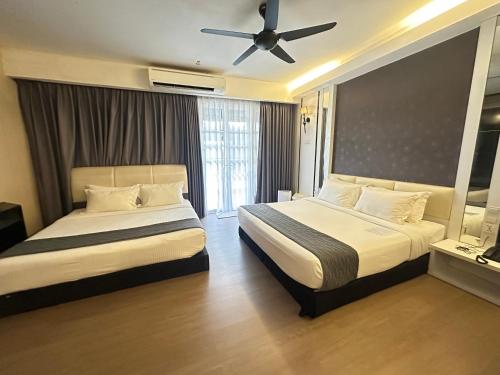 a bedroom with two beds and a ceiling fan at The Sterling Boutique Hotel Melaka in Melaka