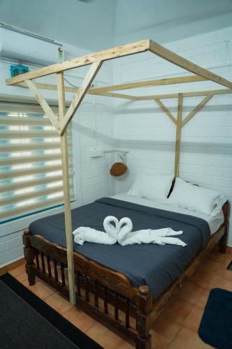 a canopy bed with two white towels on it at TempleTree Inn in Varkala