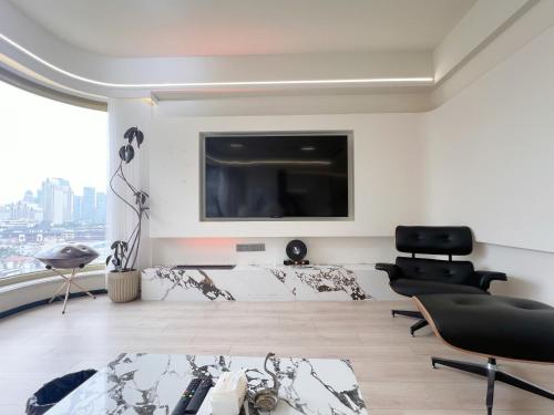 a living room with a bed and a flat screen tv at Tonight Homestay West Nanjing Road Branch Shanghai in Shanghai