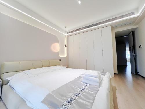 a bedroom with a large white bed with white sheets at Tonight Homestay West Nanjing Road Branch Shanghai in Shanghai