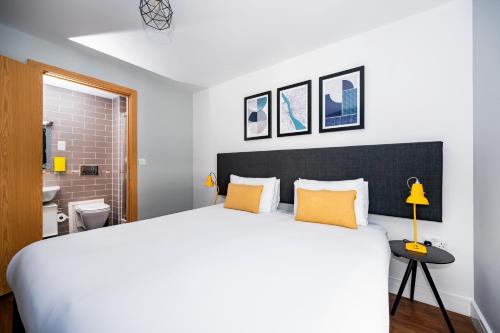a bedroom with a large white bed with yellow pillows at Staycity Aparthotels Liverpool City Centre in Liverpool