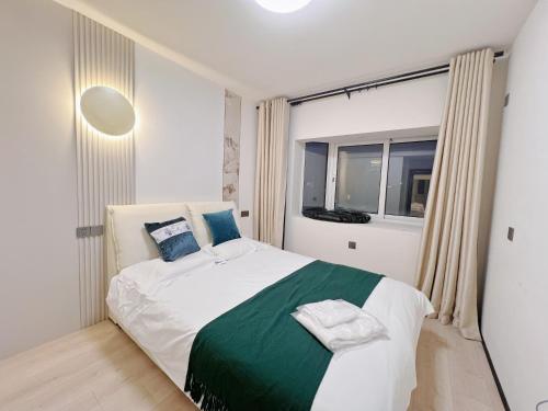 a bedroom with a bed with a green and white blanket at Tonight Homestay West Nanjing Road Branch Shanghai in Shanghai