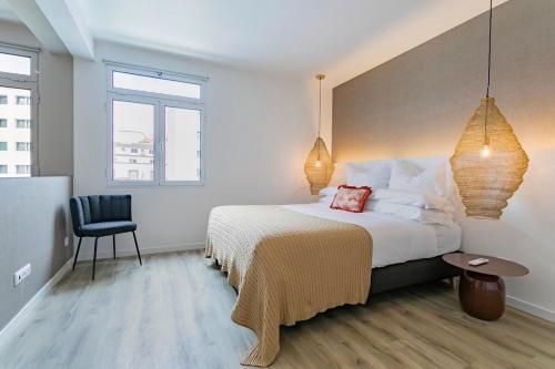 a bedroom with a large bed and a chair at GuestReady - Elegant Marina Apartment in Ponta Delgada