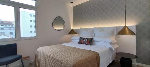 a bedroom with a bed and a chair and a mirror at GuestReady - Elegant Marina Apartment in Ponta Delgada