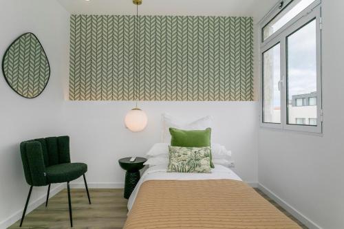 a bedroom with a bed and a chair and a window at GuestReady - Elegant Marina Apartment in Ponta Delgada