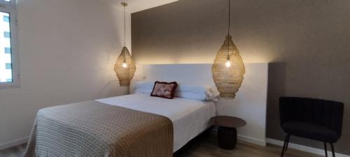 a bedroom with a bed and two lights and a chair at GuestReady - Elegant Marina Apartment in Ponta Delgada