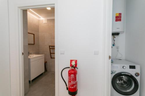 a fire extinguisher is hanging on the door of a bathroom at GuestReady - Elegant Marina Apartment in Ponta Delgada
