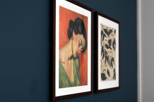 two framed paintings of a woman on a blue wall at The Chamberlain in London