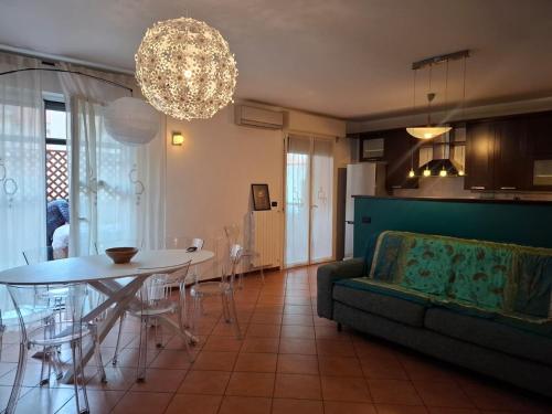 a living room with a couch and a table and a chandelier at B&B Casa Fortunata in Milan