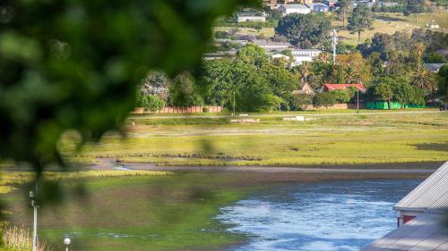 a view of a river with a town in the background at Knysna River Club Getaways - Luxury waterfront chalets in Knysna