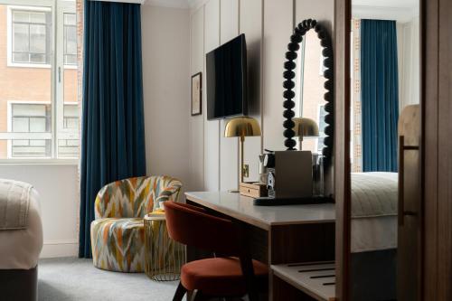 een hotelkamer met een bureau, een bed en een stoel bij The Chamberlain in Londen