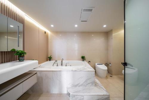 a white bathroom with a tub and a toilet at Tonight Homestay West Nanjing Road Branch Shanghai in Shanghai